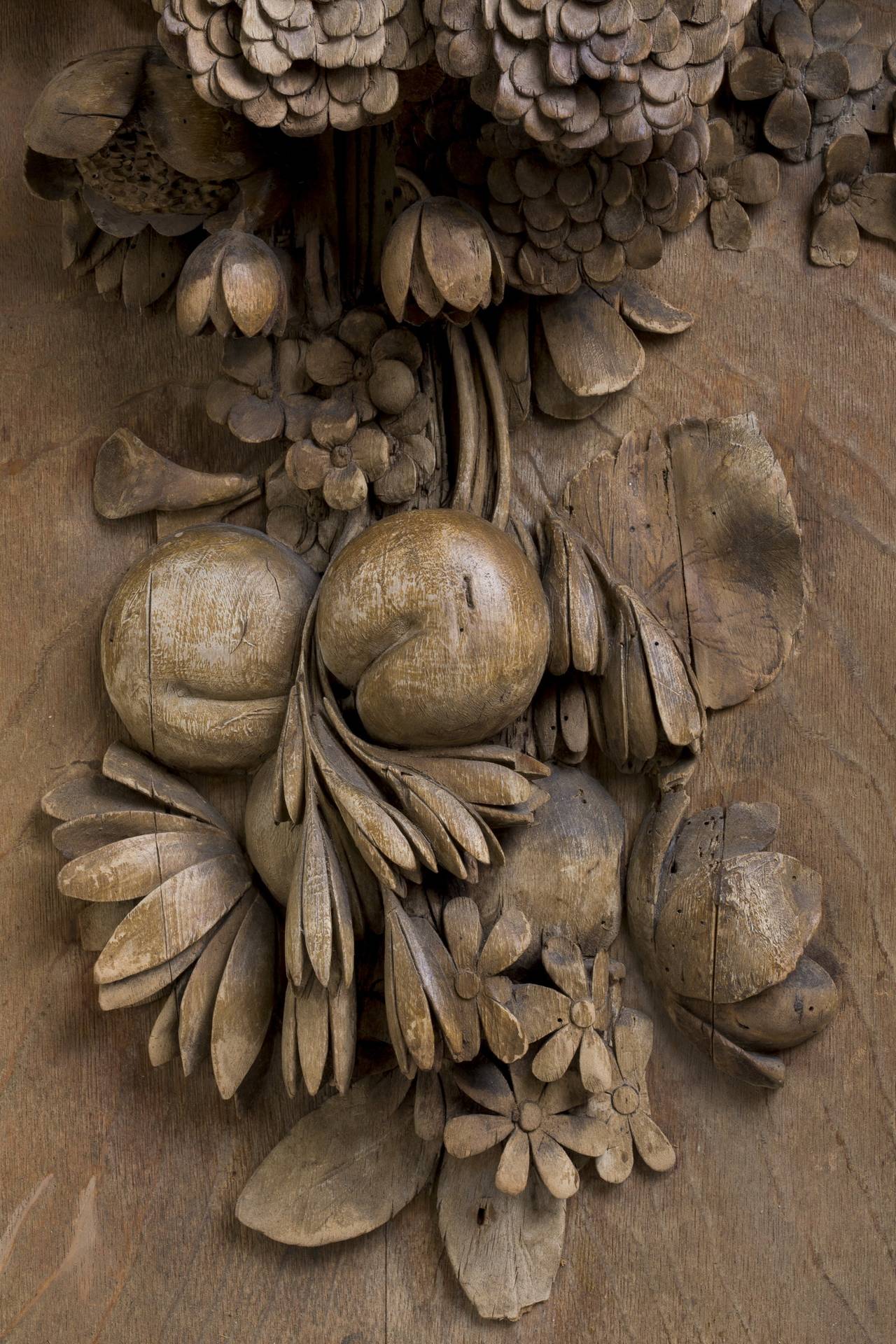 Of rectangular form, carved with ribbon-suspended grapes, pomegranates, flowers and other fruits and vegetation.
An unusual exponent of baroque sculpture, Grinling Gibbons (1648-1721) worked in all media, including marble, stone and bronze, but