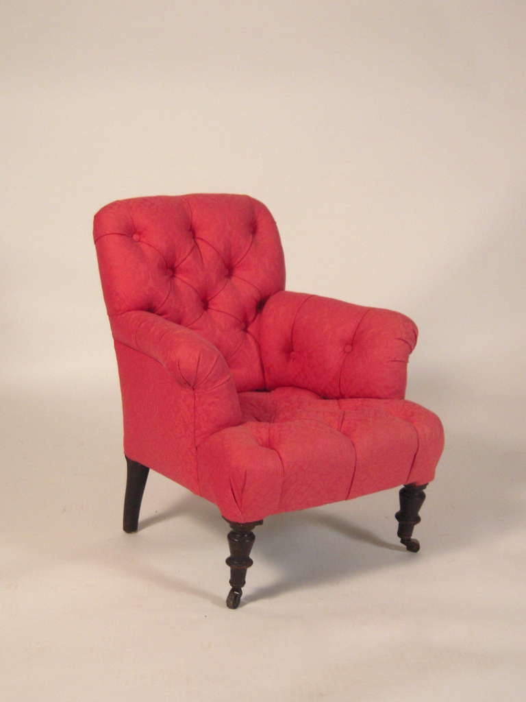 A child size Victorian armchair, in tufted scarlet upholstery, raised on turned ebonized legs and casters.

Provenance: John Cottrell, Stillington Hall, Gloucester, Massachusetts