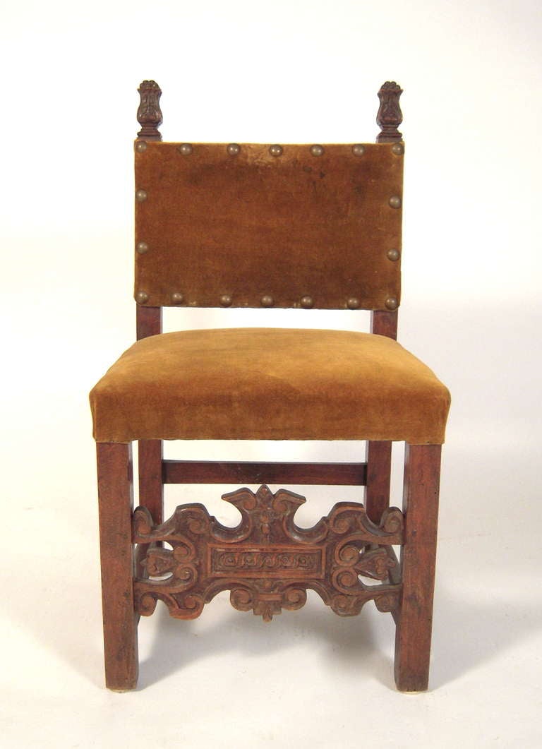 A small Spanish or Italian diminutive carved walnut side chair with olive green velvet upholstery. Wonderful as an accent chair, or surface for books, in an upholstered seating arrangement, by a fireplace, on a landing, or in a bedroom.

Measures: