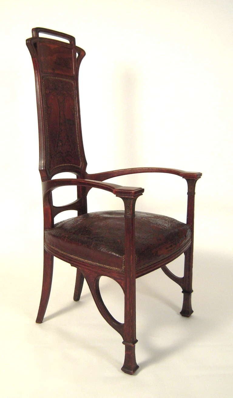 A fine quality French Art Nouveau period carved oak marquetry armchair in the manner of Louis Majorelle with original embossed leather upholstery, circa 1905.