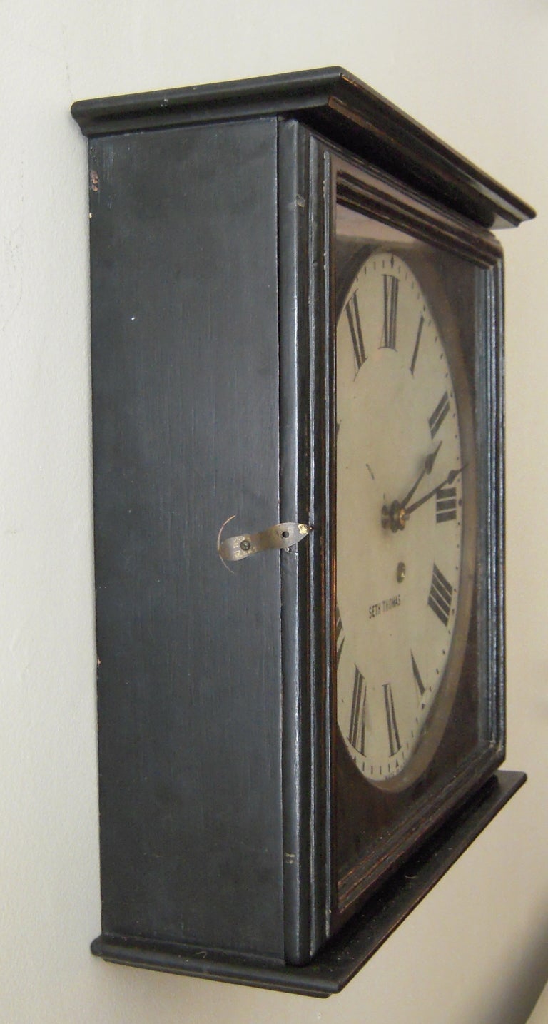 A simple 19th century style square Seth Thomas gallery wall clock, the black painted square case with glass door enclosing a round brass-rimmed metal dial with printed Roman numerals. American, circa Pendulum 8 day movement. Newly restored; keeps