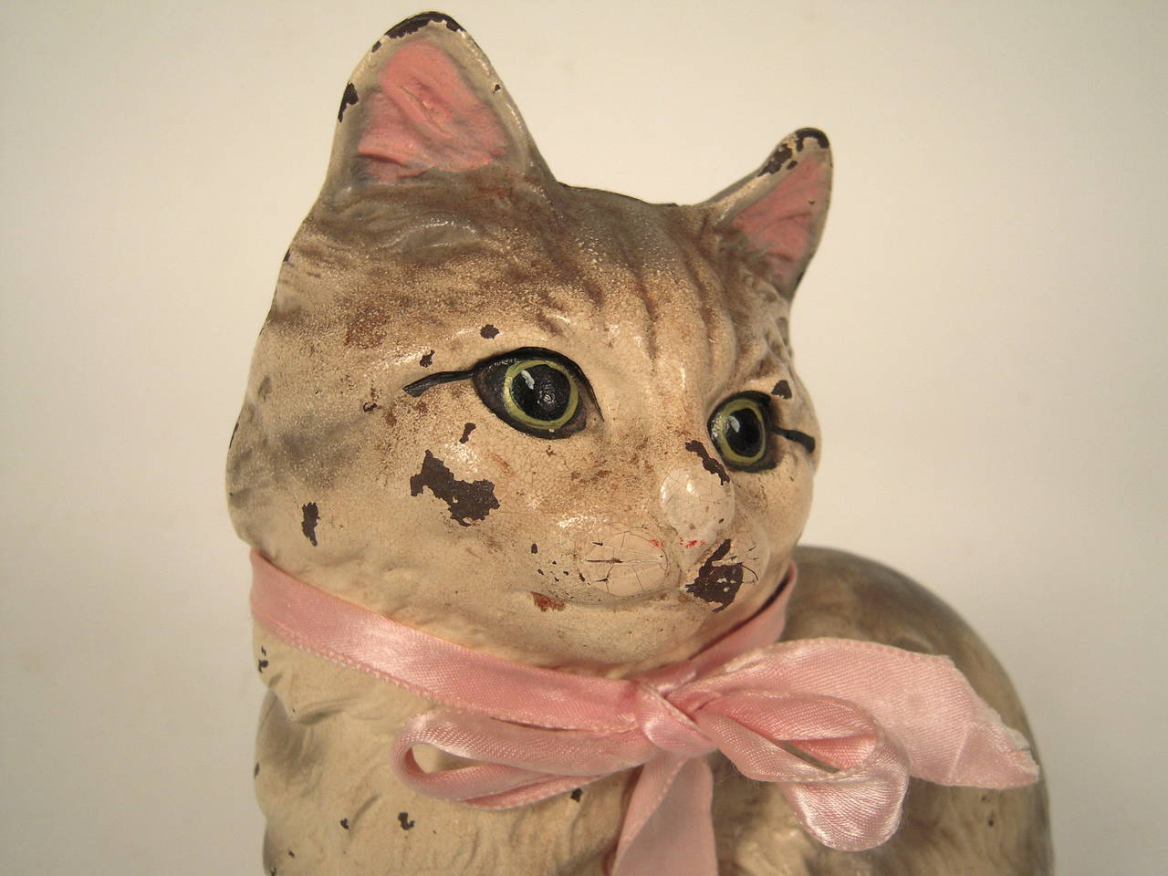 An original Hubley painted cast iron door stop in the form of a cat, retaining its original painted surface. Signed on interior of base. Pink ribbon later.