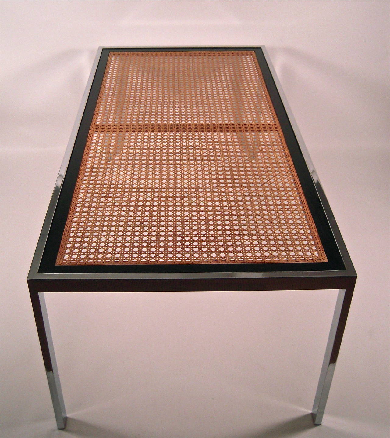 A Milo Baughman designed dining table for Thayer Coggin, American, circa 1970s, in superb condition, of rectangular form, the inset glass top supported by an ebonized hardwood and natural caned frame, within a chromed metal square