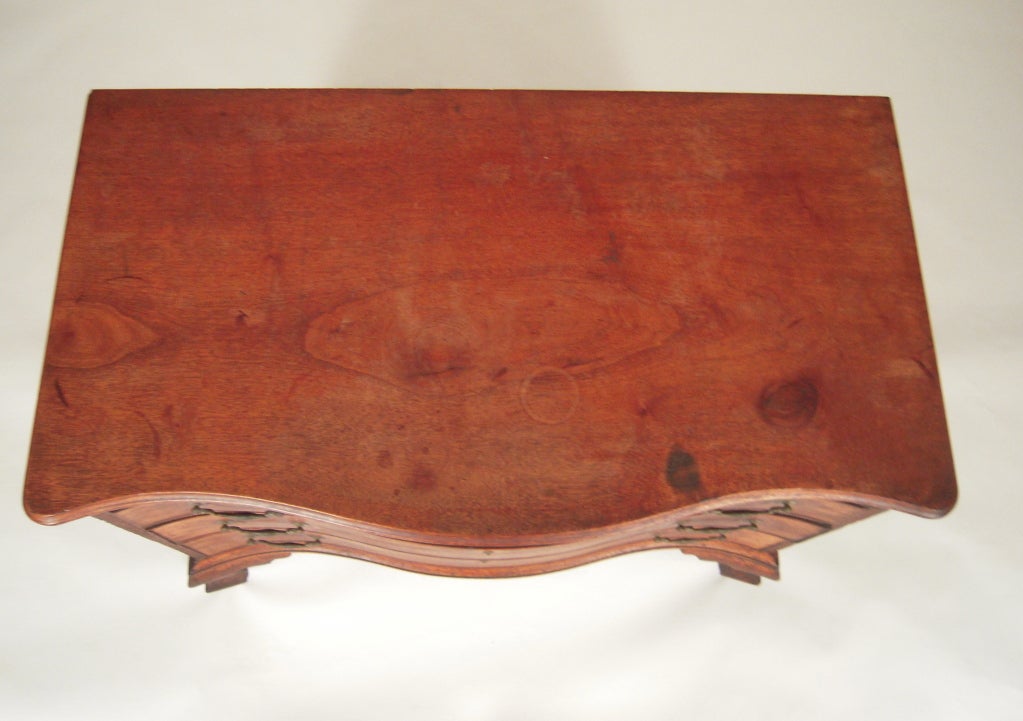A Chippendale mahogany reverse serpentine chest of drawers, Massachusetts, late 18th century, the molded top on a case of four cockbeaded graduated drawers on ogee bracket feet on platforms, retaining its original surface and original brass bail