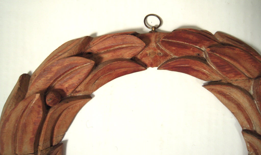 A pair of 19th century American neoclassical carved wood laurel wreath architectural ornaments.

Now in their natural wood state, with old paper backing, they were likely painted once.