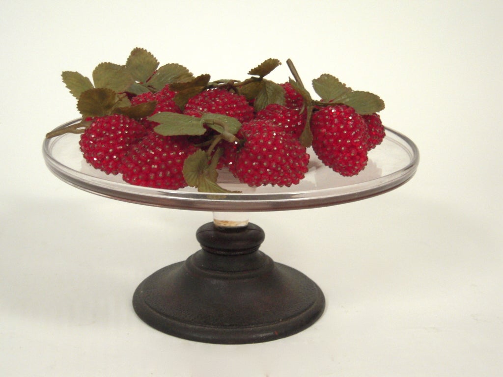 A collection of decorative hand beaded strawberries, each made with faceted red plastic beads attached with metal pins, many with green 