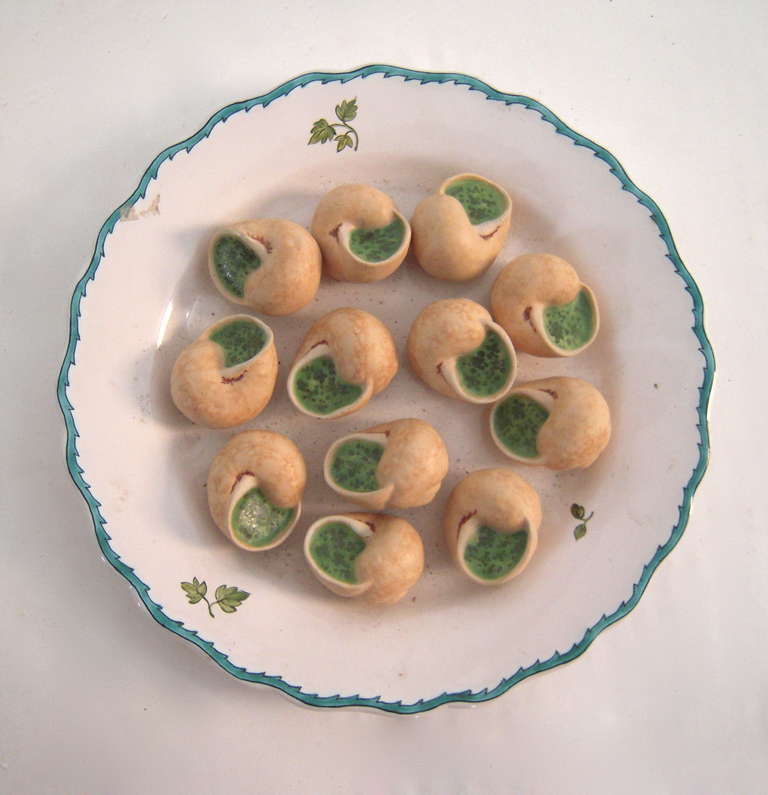 A French pottery trompe l'oeil plate, white with green glazed edge, decorated with realistically modeled escargots on a white glazed plate with green glazed scalloped edge, by Figueres, France.