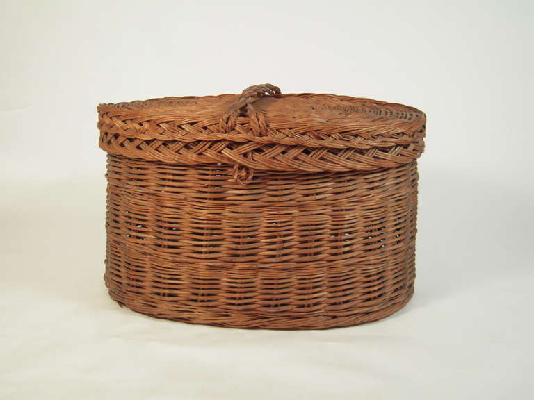 A very large oval covered rattan basket, perfect for a mudroom, wood storage by a fireplace, laundry and/or decoration.

Height: 23