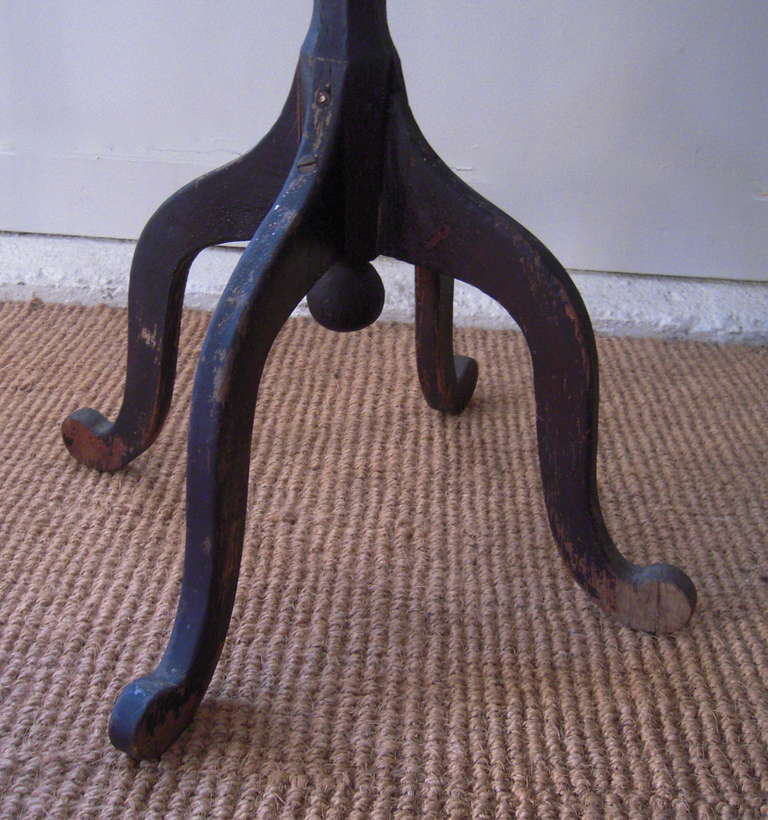 A whimsically shaped, painted 19th century candlestand with circular top and scrolled legs, New England or, possibly, Canadian.