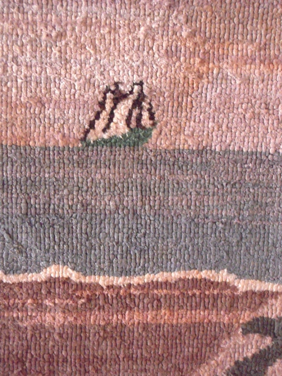 A Folk Art Grenfell fisherman hooked mat by the Grenfell Labrador Industries, Newfoundland and Labrador, early 20th century, composed of bleached and dyed cotton and silk strips hooked onto a burlap support, depicting a fisherman, gathering or