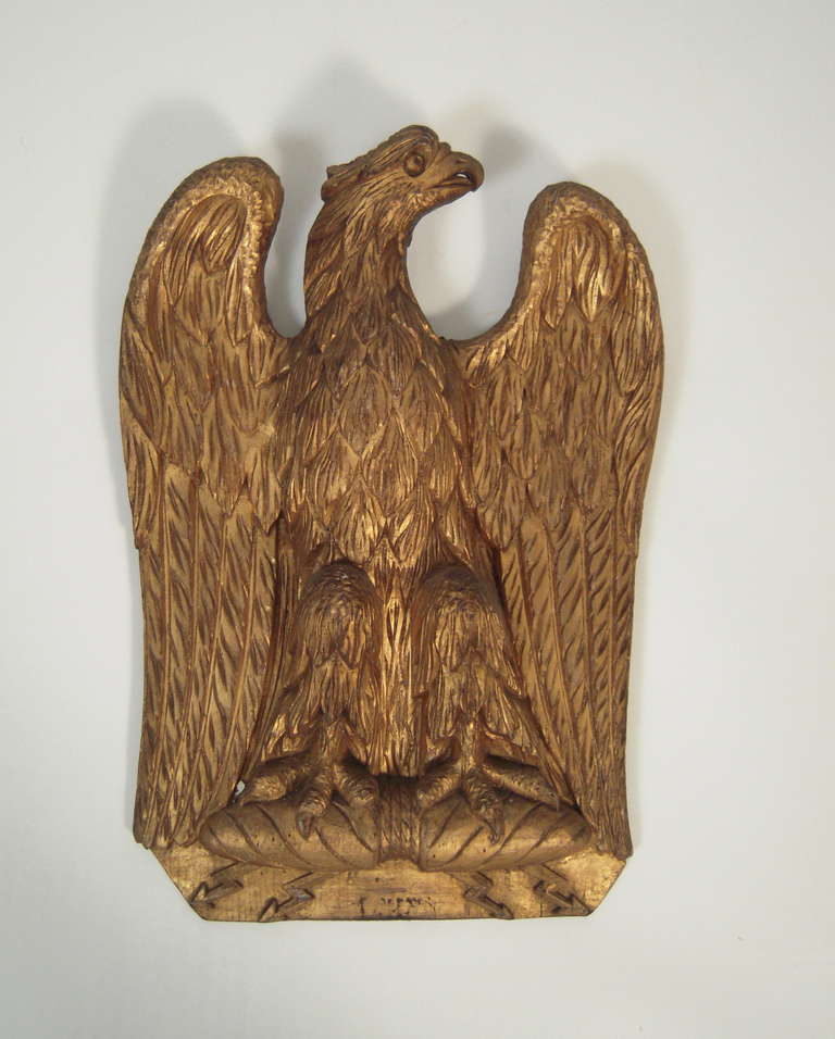 A carved and gilded American eagle wall decoration, with head turned left, wings spread and talons clutching lightening bolts.

Provenance: Henry Davis Sleeper, Stillington Hall, Gloucester, Massachusetts where it hung in the theater since the