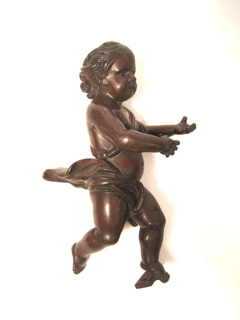 A pair of 19th century well modeled three dimensional bronze putti, originally architectural or furniture ornaments from a house in Salem, Massachusetts. Beautiful as wall decoration or as table top ornaments.

May be wall mounted or displayed