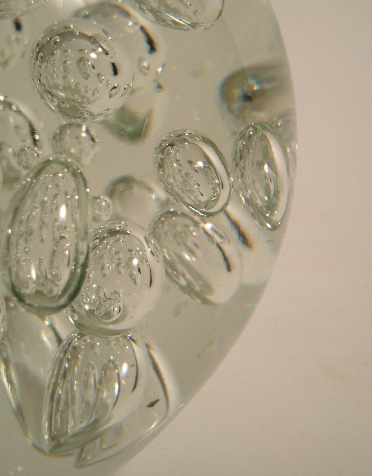A large circular colorless glass  paperweight, with large air bubbles inside, on a flat base, possibly Murano, Italy. Fabulous, sculptural decoration. Could be used as a door stop, too.
