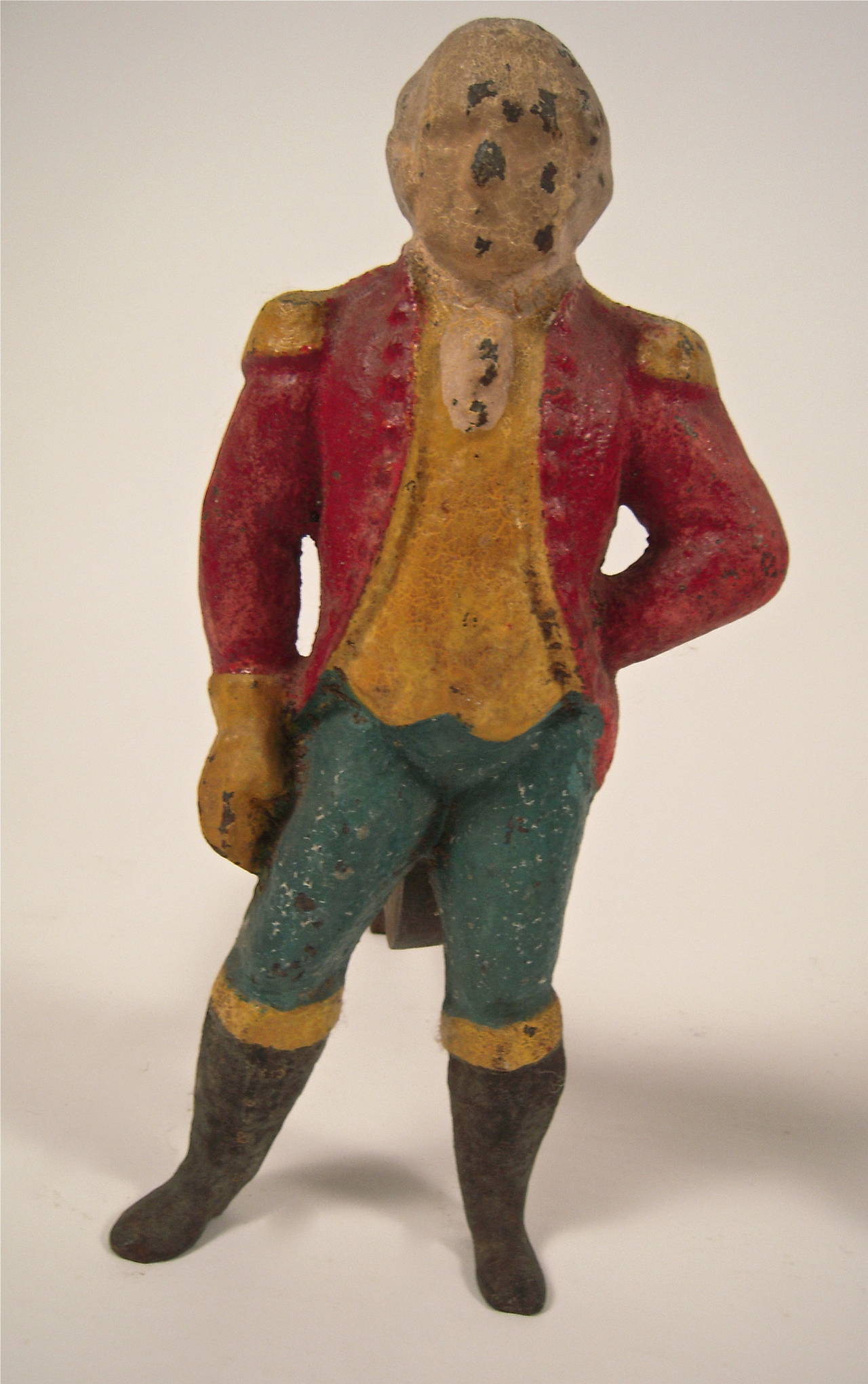A pair of painted cast iron George Washington figural andirons with wonderful, original painted surface. These andirons are small scale with detachable iron supports. The George Washington figures could also be converted to lamp bases.