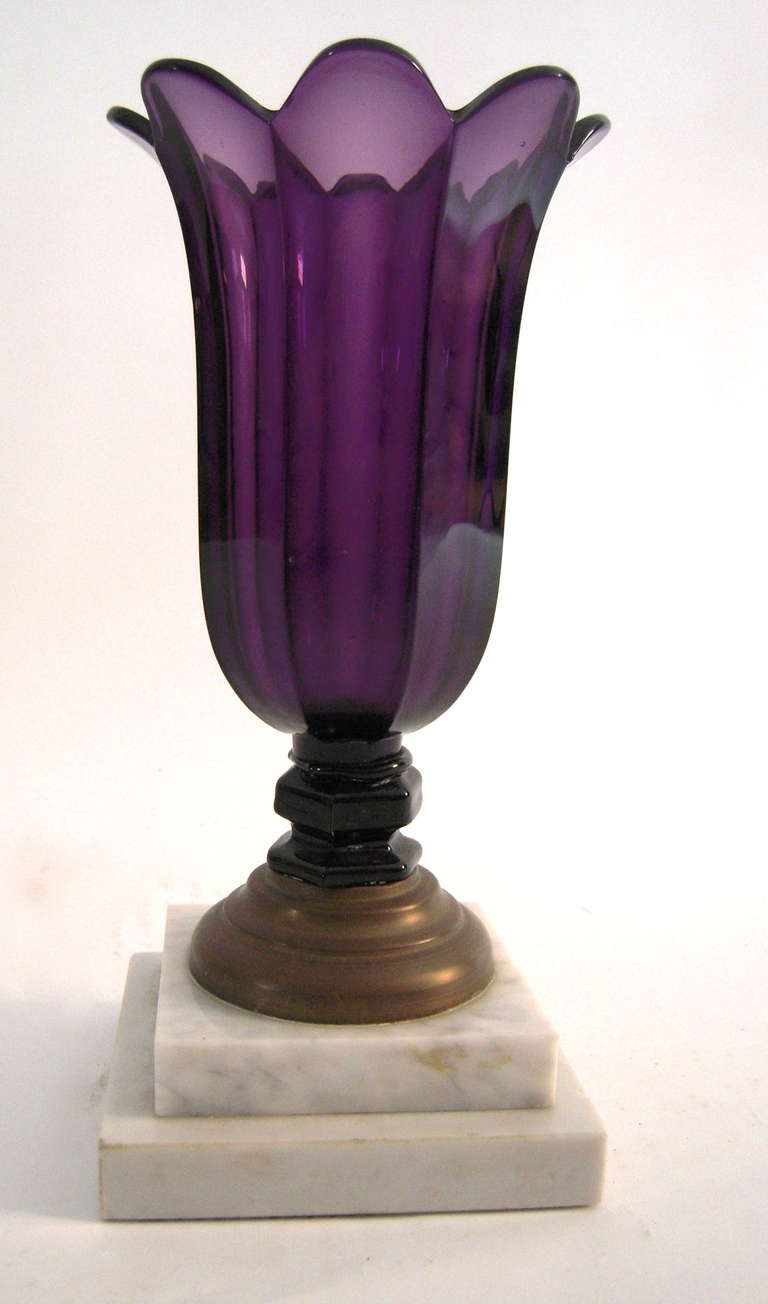 A 19th century amethyst tulip glass vase, on a 'make do', old, but later, imaginatively  repaired base consisting of a circular grass foot on a square stepped marble plinth.

Provenance: Henry Sleeper, John Cottrell, Stillington Hall, Gloucester,