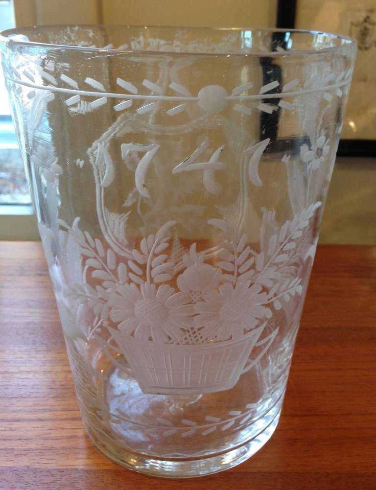 A large wheel engraved and blown colorless glass Flip glass, of typical form, one side decorated with an armorial shield centered by a 'lion rampant', the other side with a basket of flowers underneath the date '1741'.

Originally made to hold