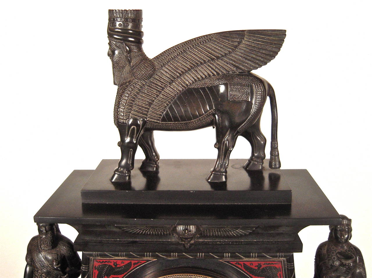 A fine quality French bronze-mounted incised black marble (marmo nero Belgio) striking mantel clock in the Assyrian Revival style, circa 1860,
the substantial, architectural case surmounted by an Assyrian winged guardian (known as a Lamassu) and