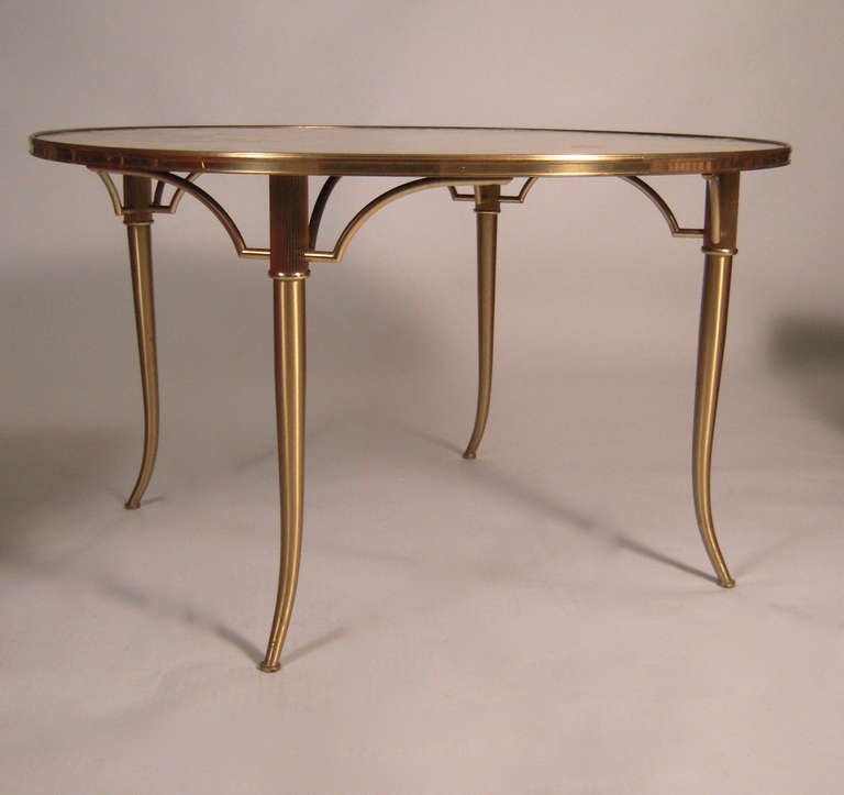 A stylish Hollywood Regency period Billy Haines designed suite of furniture, a 'party table' and four chairs, consisting of a solid brass round table, the overlapping capiz shell veneered top surrounded by a brass gallery and raised on 4 saber legs