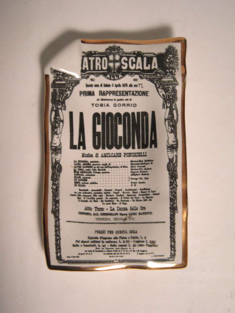 Two Piero Fornasetti opera themed, gold edged,  white glazed earthenware dishes, transfer printed as trompe l'oeil dog-eared advertising posters for La Scala's productions of 