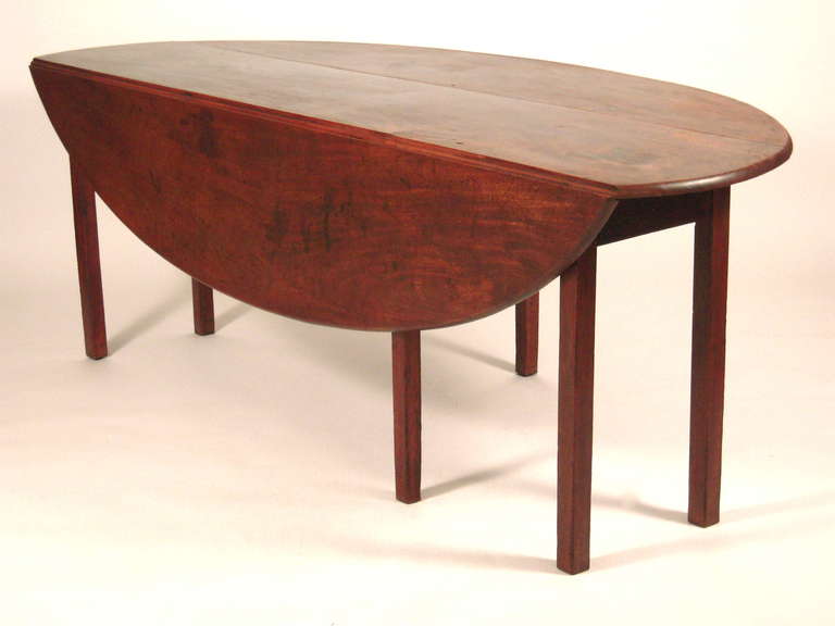 A  large George III drop leaf oval 'wake' or hunt table, in mahogany, with plum pudding surface, with 2 drop leaf oval leaves, raised on square section legs. 
Versatile as a sofa table, demilune table or oval dining table.
Beautiful, simple form,