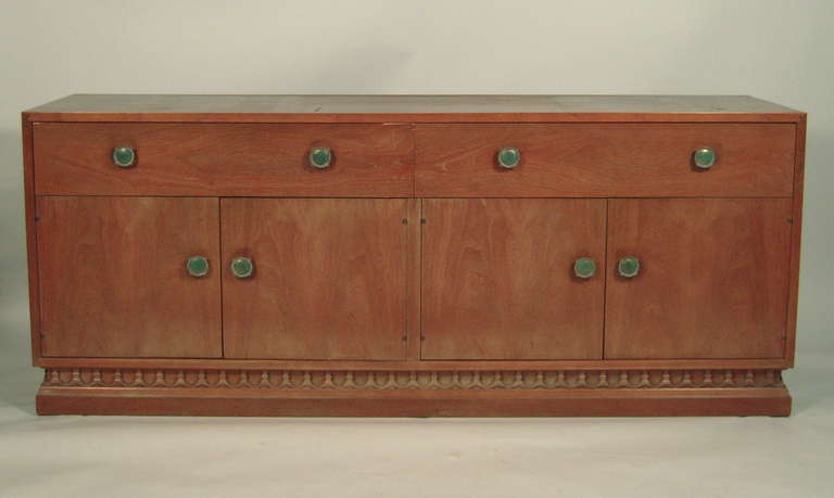 A  two-part cabinet in bleached walnut with yellow and green floral stencil decoration, derived from Scandinavian folk motifs, designed by John Van Koert's for Drexel. The tapered upper section features two removable sliding doors enclosing shelves
