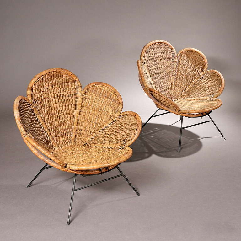 A pair of wicker garden or patio chairs with petal form seats and backs on black painted iron frames and bases. Very comfortable.