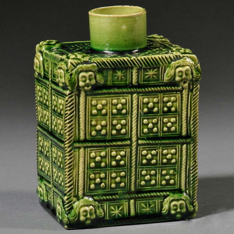 A rare Staffordshire green glazed earthenware tea canister, or caddy, English, c.1760, of rectangular form with press-molded domino panels, each corner with spirally turned columns and applied masks, in excellent condition, with no restoration.