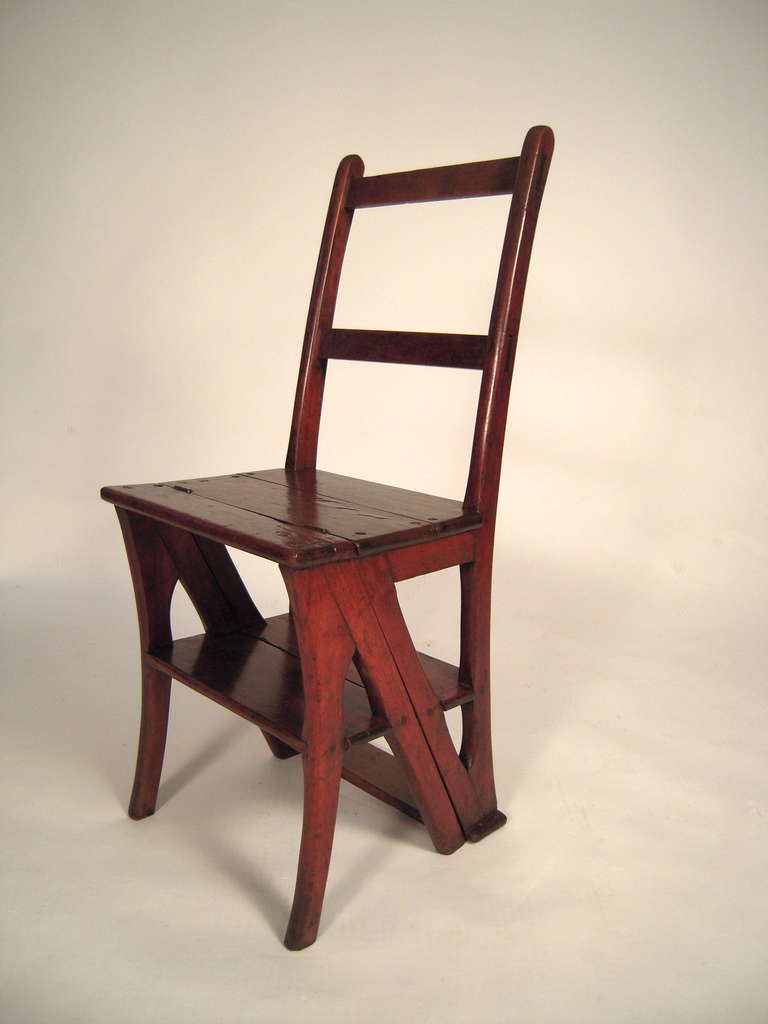 A metamorphic  walnut chair which converts into a step ladder. The hinged ladder back flips over to form steps which are incorporated into the design of the chair base. French or French Canadian.