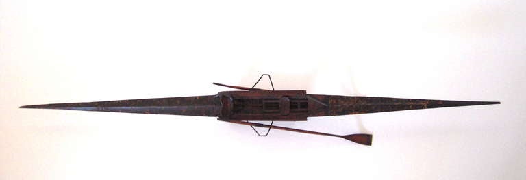 A rare, beautifully crafted model of a single scull rowing shell, American, circa 1890-1910, with finely detailed interior, including foot rests and an adjustable sliding seat, the exterior in wood and painted vellum, with 2 finely articulated oars