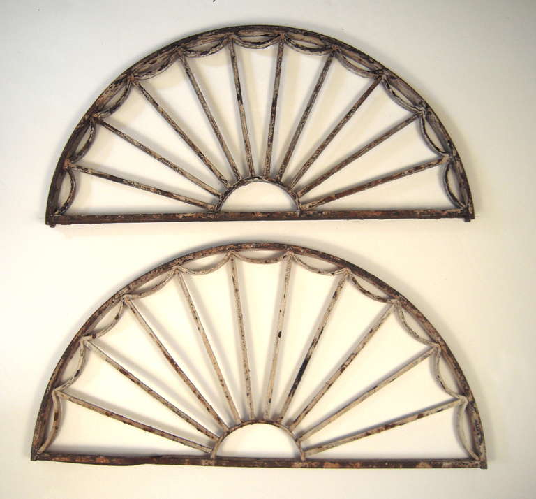 A pair of Federal style painted cast iron fanlight window frames, from Beacon Hill, Boston, circa 1880s, in old crusty grey and white paint. Decorative, wall decoration, as overdoors, or mounted as a circle.