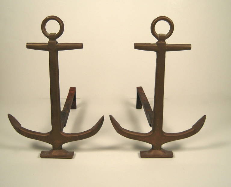 A pair of brass anchor andirons with cast iron supports.