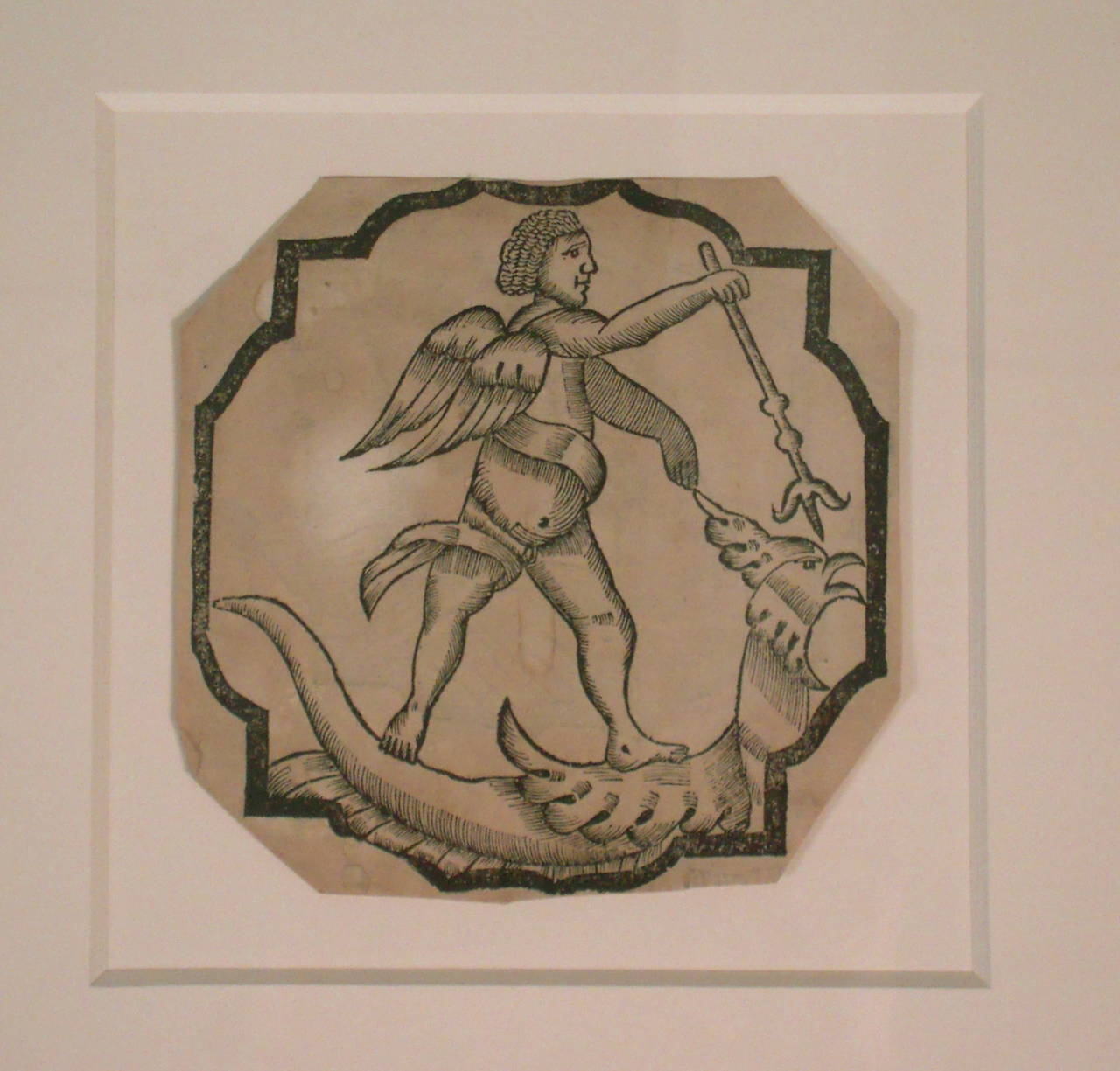 A charming, decorative early woodcut print on paper of Saint (Archangel) Michael slaying the dragon,16th century, within a bracketed square black border, trimmed as an octagon, newly, archivally framed--matte floated with 8-ply acid-free matte and