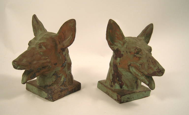 A pair of German Shepherd bookends in cast metal with applied verdigris patina, impressed 'Buddy' and 'The Original seeing Eye Dog for the Blind
