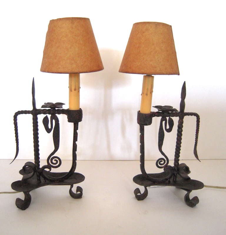 A pair of wrought iron table lamps with vellum/paper shades..

Newly re-wired.