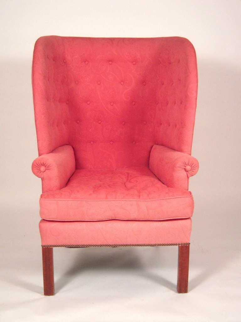 A comfortable, cozy and sculptural Colonial Revival barrel back wing chair upholstered in high quality faded scarlet fabric, raised on square section, chamfered cherry legs.

Provenance: Stillington Hall, the celebrated stone and half timber