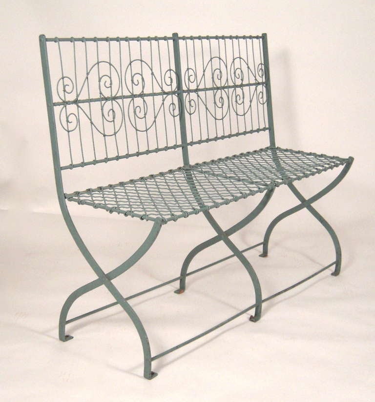 A blue painted metal garden bench, the rectangular back support with vertical and scrolling decoration over a conforming mesh seat raised on X-shaped legs joined by cross stretchers.
Very sturdy and comfortable.