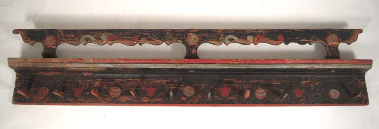A 19th century paint decorated European (Swedish or Austrian?)  country hat and coat rack, the scalloped carved top rail over a projecting cornice above 9 wood hooks, decorated overall with worn painted slate blue, red and white  geometric