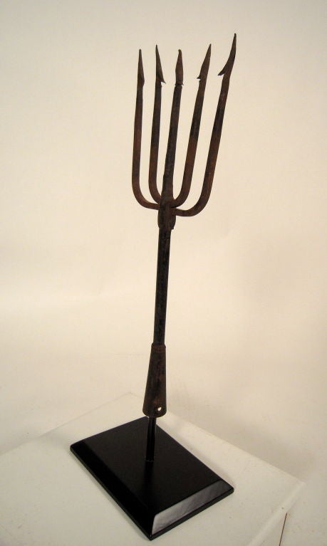 An early American  wrought iron eel and fishing spear mounted on an ebonized wood base. 1 of 3 available. Graphic and decorative.
