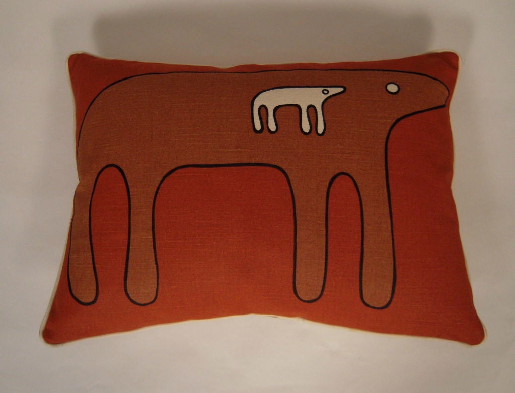 A printed fabric pillow, with animal forms in orange, brown and black on a cream colored background, designed by Angelo Testa and produced by Angelo Testa & Company, Chicago, IL. Down filled, with welted edges.<br />
<br />
Angelo Testa was born