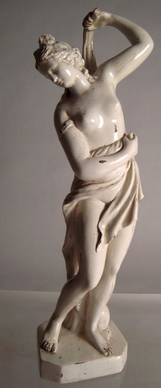 An Italian Neoclassical style white glazed ceramic figure of Venus at Her Bath, a copy of the celebrated ancient Roman (1st century BC, after a Greek bronze)  sculpture known as  