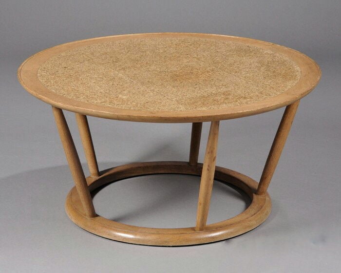 A coffee table designed by Edward Wormley for Dunbar, the circular light mahogany  top inset with cork, raised on five spindles joined by a smaller circular ring base.