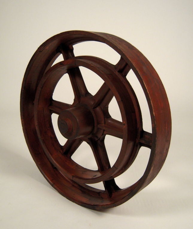 A well patinated, old wood circular foundry mold, used for the casting of metal gears and pulleys. Graphic and sculptural as wall decoration.