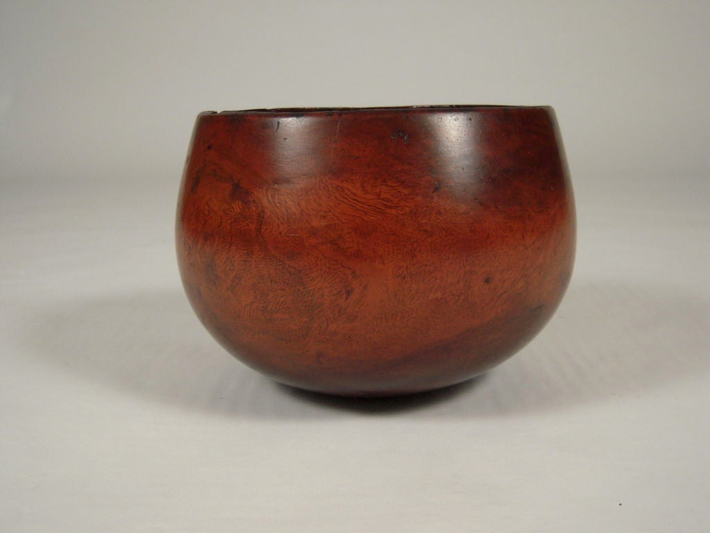 Rare early 19th century hand carved Hawaiian Kou wood poi bowl of elegant calabash form. The best of these poi bowls copied the gourd, and this bowl has a wonderful organic form. Its base rests on a point, and it seems to float on the table. This