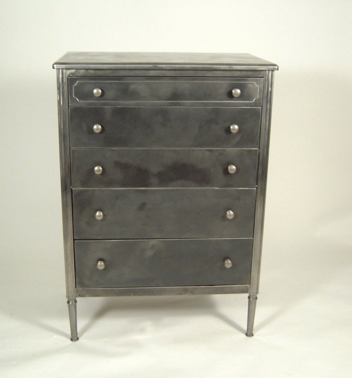 A vintage American steel Sheraton style tall chest of drawers with built in fall-front secretary. The third drawer from the top opens down to reveal a pull out, sliding writing surface and storage compartments. Versatile in both style and function.