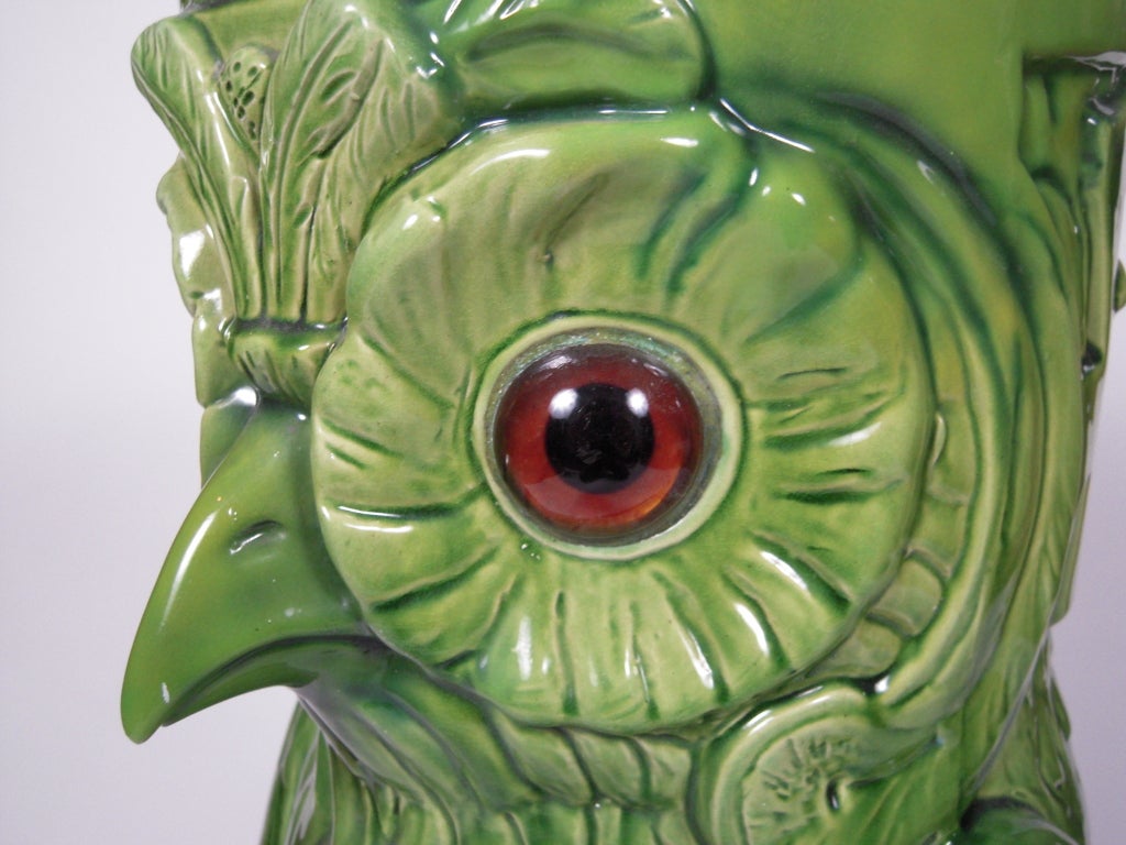 A Bretby earthenware green glazed umbrella and walking stick stand, modelled as an owl with amber and black glass eyes.  Signed with impressed marks on base.