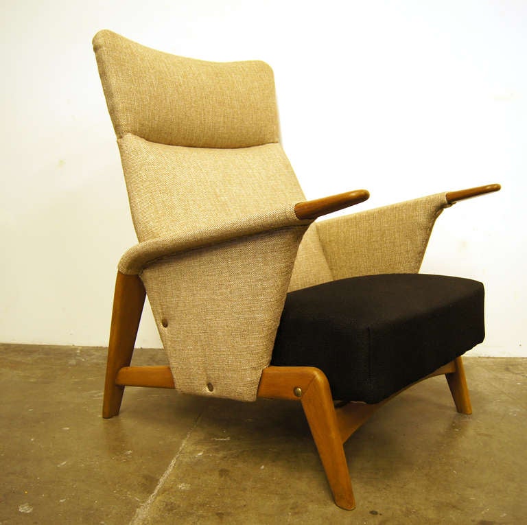 This unique high-back armchair features original two-tone upholstery in black and oat on a partially exposed solid oak frame. 