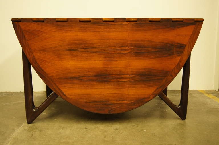 This drop-leaf dining table features stunning rosewood grain and unique spider-like legs. Each leafs is 24