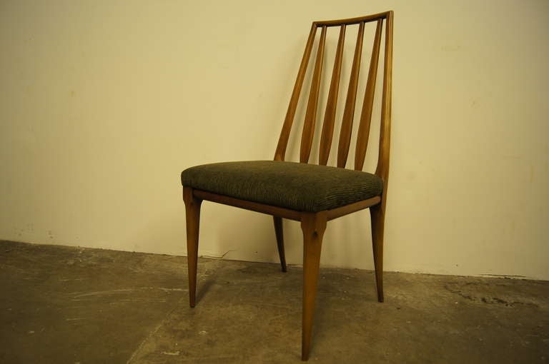 Diseñado por John Widdicomb, este elegante juego de seis sillas de comedor presenta armazones de cerezo macizo con respaldos cónicos y patas esbeltas. Los asientos están tapizados en un rico verde musgo. 

Etiqueta original en la parte inferior.