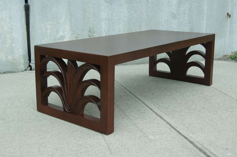 This coffee table by T.H. Robsjohn-Gibbings features sculptural plumed sides and has been expertly refinished. Original tag on underside of table. 