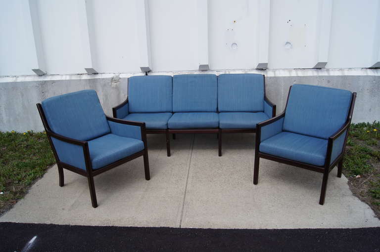 This living room set was designed by Ole Wanscher and includes one sofa and two chairs. All items are constructed of a dark mahogany frame and feature the original textile. This set should be refinished and reupholstered.

 The chairs each measure
